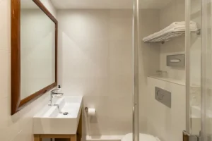 Salle de bain moderne avec douche et lavabo.