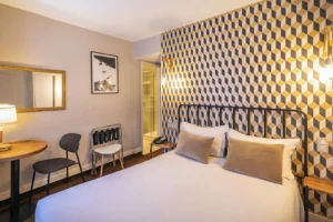 Chambre moderne avec lit double et décoration géométrique.