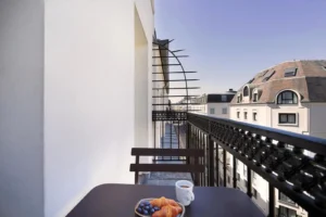 Petit-déjeuner sur un balcon avec vue urbaine.