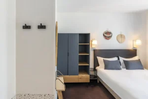 Chambre d'hôtel moderne avec lit et armoire.