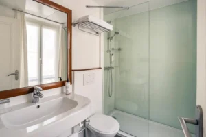Salle de bain moderne avec douche vitrée.