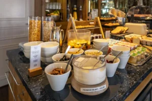 Buffet petit-déjeuner varié avec céréales et yaourt.