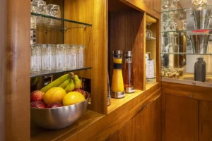 Bol de fruits et jus sur étagère en bois.
