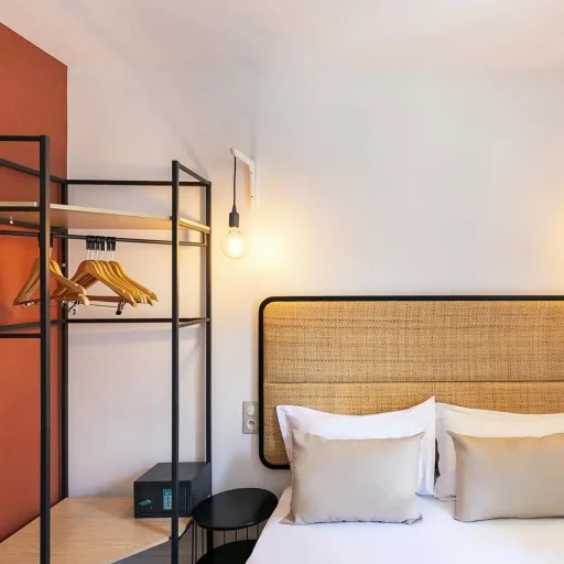 Chambre d'hôtel avec lit double et étagères ouvertes.